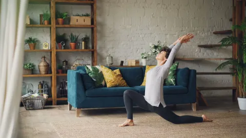 Mulher se alongando na sala de casa aconchegante