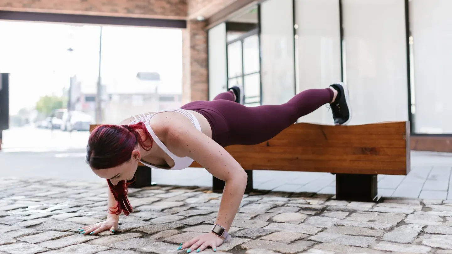 Mulher fazendo flexão de braço no chão durante treino em casa Mulher fazendo flexão de braço no chão durante treino em casa