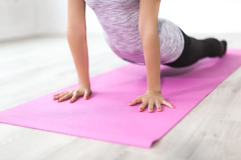 Mulher apoiada em prancha sobre colchonete, ativando o core no chão para exercícios de mat pilates Mulher apoiada em prancha sobre colchonete, ativando o core no chão para exercícios de mat pilates