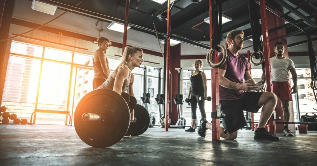 instrutor dando dicas pra mulher fazendo levantamento terra
