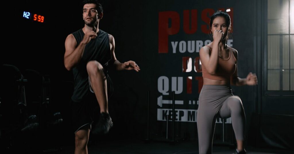 casal fazendo hiit na academia perto de um cronometro
