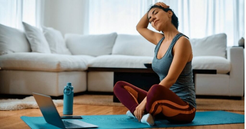 mulher alongando pescoço na frente do pc
