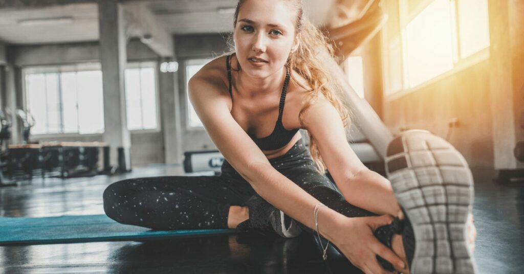 mulher loira fazendo alongamento