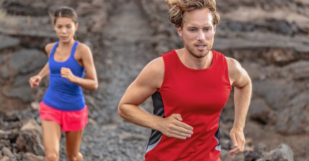 casal correndo em terreno rochoso