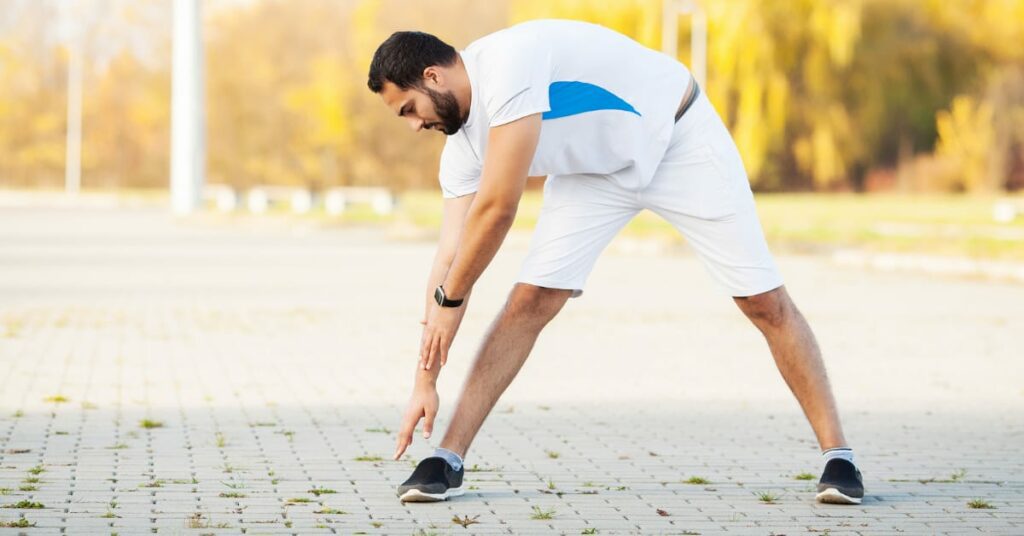 homem fazendo alongamento antes de correr