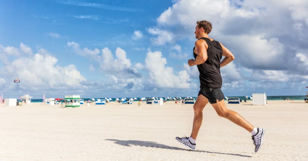 homem fazendo corrida na praia