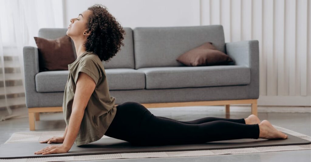 mulher fazendo pilates em frente ao sofá